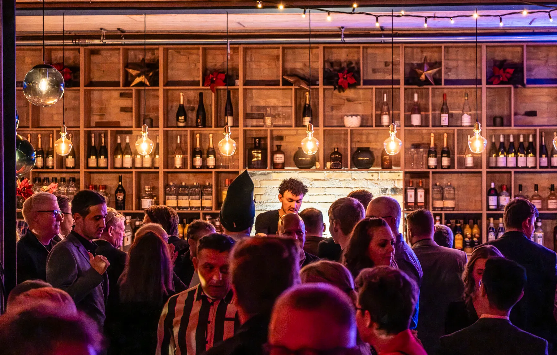 Festlig stemning ved Ø6 Odense C. Bar med mennesker og lysdekorationer. Perfekt til events og sociale sammenkomster.